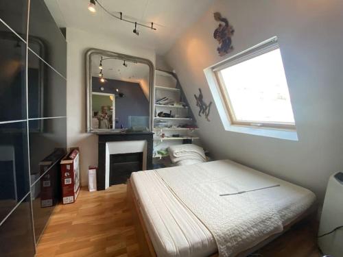 une petite chambre avec un lit et un miroir dans l'établissement Studio entre Étoile et Trocadéro, à Paris