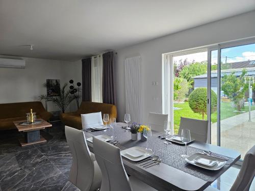 a dining table and chairs in a living room at Maison Paray- Orly- Parking Privé in Paray-Vieille-Poste
