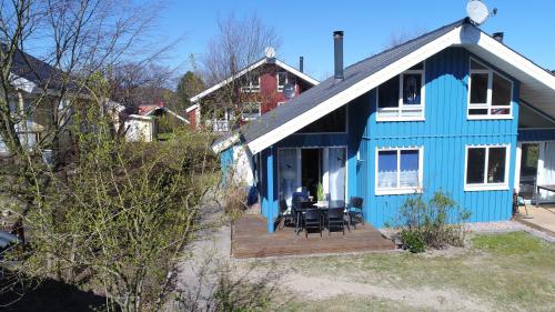 una casa azul con una mesa y sillas en un porche en Ferienpark - Komfort-Ferienhaus mitten in der Natur 5 Personen, en Extertal