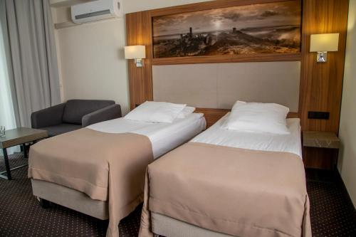 ein Hotelzimmer mit 2 Betten und einem Stuhl in der Unterkunft Hotel Villa Verde Congress & Spa in Zawiercie Nowe