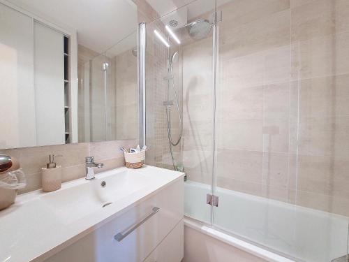 une salle de bain blanche avec une douche et un lavabo dans l'établissement V-Landes 06-Vieux Boucau appartement 6 personnes dans résidence avec piscine face au lac marin, à Vieux-Boucau-les-Bains