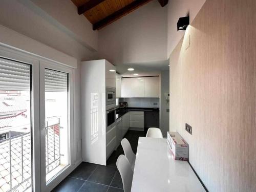 a kitchen with a white table and white chairs at Mati's Suite - San Torcuato 4 in Zamora