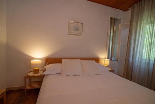 a bedroom with a large white bed with two lamps at Stokic in Veli Lošinj