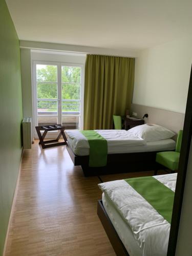 una camera d'albergo con due letti e una finestra di Haus Villigst - Tagungsstätte der EKvW a Schwerte