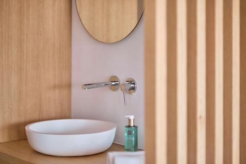 baño con lavabo blanco en la encimera en Las Gaviotas Suites Hotel & Spa, en Playa de Muro