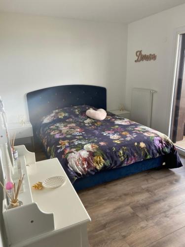 a bedroom with a bed with a floral comforter at L’élégance au bord du Lac in Évian-les-Bains