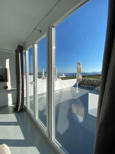 a room with a large window with a view of the ocean at Serenità Luxury Suites in Akrotiri