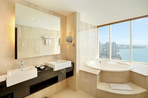 ein Badezimmer mit zwei Waschbecken und einem großen Fenster in der Unterkunft Swiss-Belhotel Balikpapan in Balikpapan