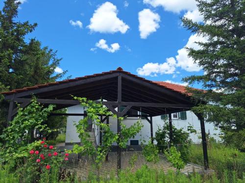 a white house with a pergola and flowers at Sailing Forever Bungalow in Kaštela