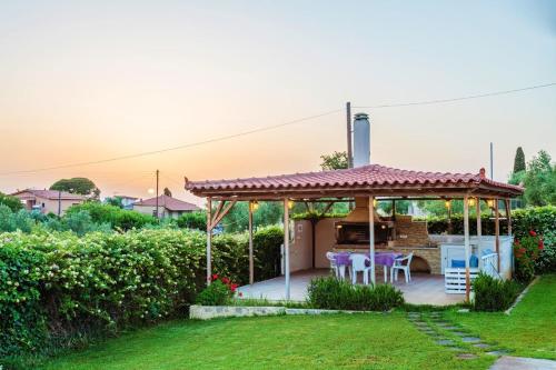a gazebo with a table and chairs in a yard at Casa Rosa Villa in Zakharo