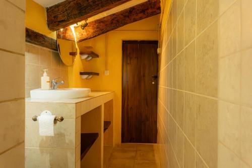 a bathroom with a sink and a mirror and a door at Masia en plena naturaleza y tranquilidad in San Quintín de Mediona