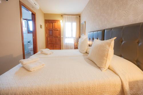 a bedroom with two beds with white pillows at La Asomada del Gato in La Laguna