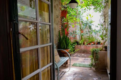 an open door to a garden with a bench outside at La Asomada del Gato in La Laguna