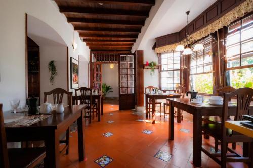 a dining room with tables and chairs and windows at La Asomada del Gato in La Laguna