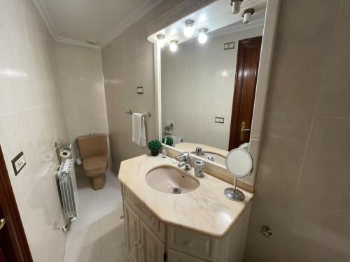 a bathroom with a sink and a large mirror at Bermeo Park - centrica casa independiente in Bermeo