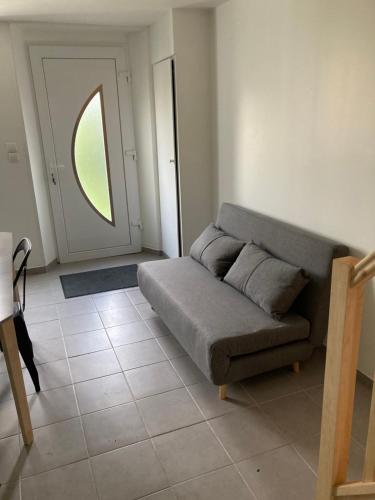 ein Wohnzimmer mit einem Sofa und einem Fenster in der Unterkunft Gîte de Broy in Vicq-dʼAuribat