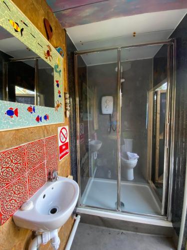 a bathroom with a shower and a sink and a toilet at Sunrise Cabin in Carbis Bay