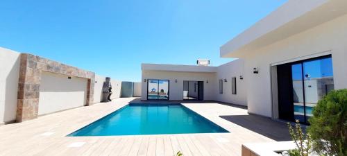 a swimming pool in the backyard of a house at Villa mima in Houmt Souk