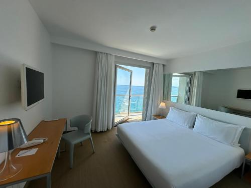 a hotel room with a bed and a desk and a window at Hotel Miramare - Adults Only in Trieste