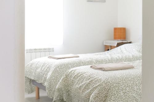 une chambre avec deux lits avec des draps blancs et une fenêtre dans l'établissement Maison récente idéalement située aux Sables dOlonne - 4 pers, à Les Sables-dʼOlonne