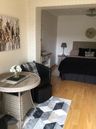 een woonkamer met een tafel en een bed bij Forest B & B in Ringwood