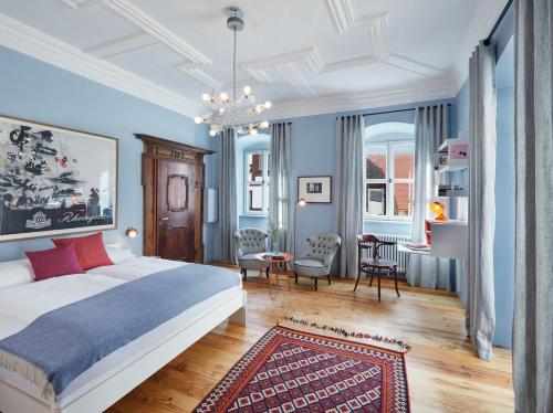 a bedroom with blue walls and a bed with a rug at Engelwirt Hotel & Apartments in Berching