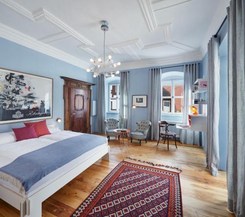 1 dormitorio con paredes azules y 1 cama con alfombra en Engelwirt Apartments en Berching