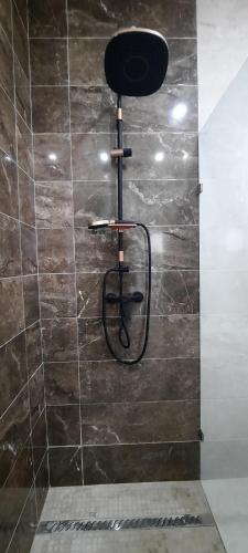 a shower with a black stool in a bathroom at Villa mima in Midoun