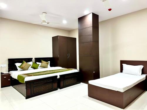 1 dormitorio con 2 camas y armario en SASA INN, en Jamshedpur