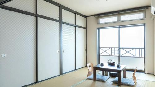 a room with a table and chairs and a window at Sennenmatsu in Imabari