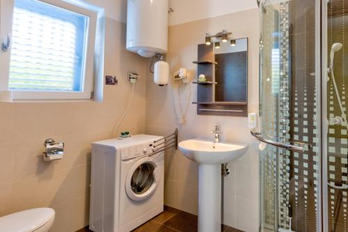 a bathroom with a washing machine and a sink at Villa Moletto Apartments with Sea view in Lovrečica