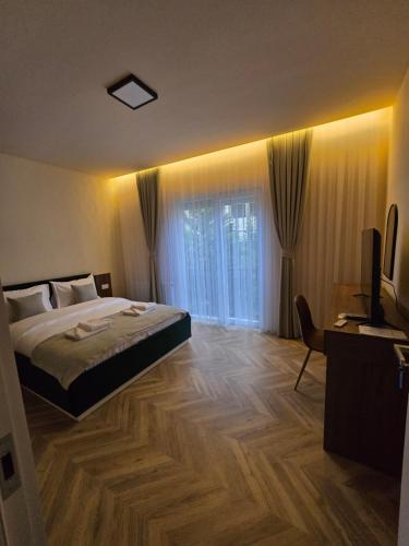 una camera con un letto e una televisione di In Town Boutique HOTEL a Pristina