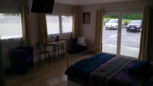 a bedroom with a bed and a table and chairs at Aquadetente loudeac in Loudéac