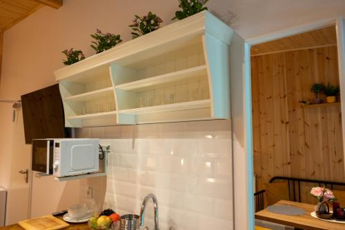 a kitchen with white cabinets and a microwave at Montebelo Villas in Veliko Tŭrnovo