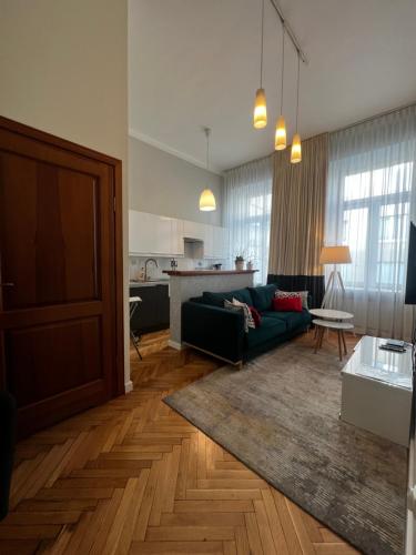 a living room with a green couch and a kitchen at Apartament centrum in Warsaw