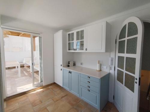 a kitchen with white cabinets and a large window at Living Luzia in Santa Luzia