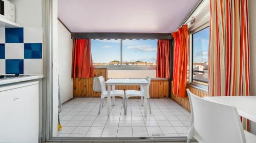 une cuisine avec une table et des chaises et une fenêtre dans l'établissement PRIMAVERA - 301 - Appt Lumineux 4 pers, au Cap d'Agde