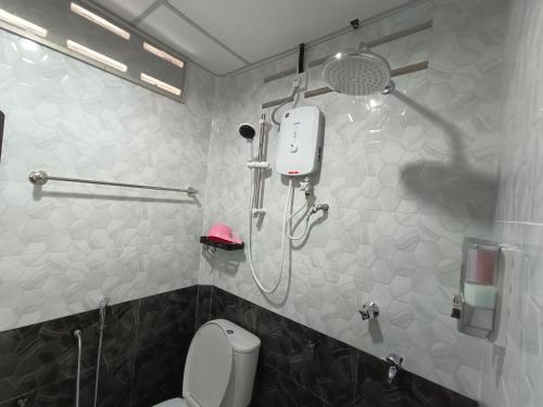 a bathroom with a shower and a toilet in it at ROOMSTAY NIMAZA Bilik 1 in Marang