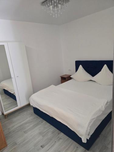 um quarto com uma cama branca e um espelho em Terra Residence Beiuș em Beius