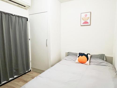 a bedroom with a bed with an orange pillow on it at 池袋2分 3Rooms 6人可 in Tokyo