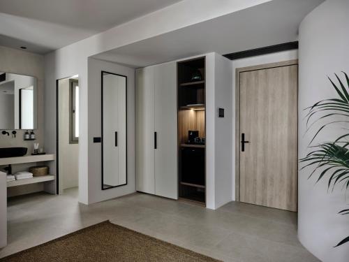 a hallway with a wooden door and a bathroom at Bond Smart Living Suites in Athens