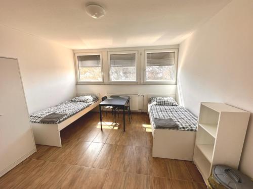a room with two beds and a table in it at Monteurunterkunft Wolkersdorf in Schwabach