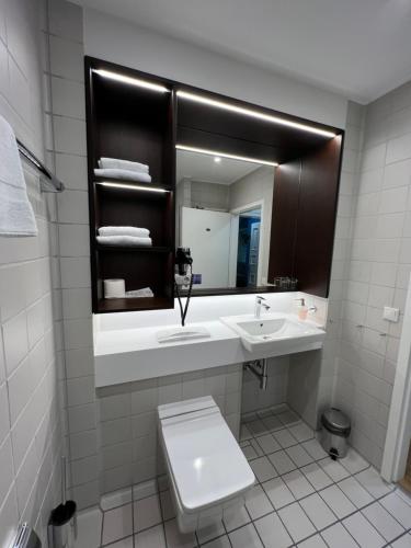 bagno con lavandino, servizi igienici e specchio di Haus Villigst - Tagungsstätte der EKvW a Schwerte
