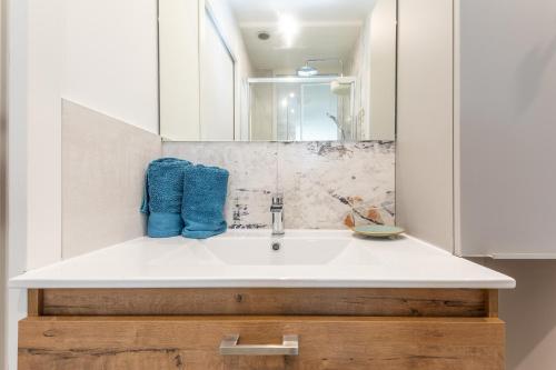une salle de bain avec un lavabo blanc et un miroir dans l'établissement Maracuja Port Nature, au Cap d'Agde