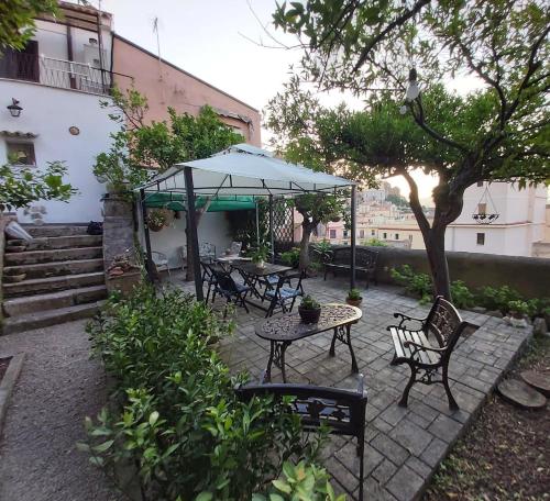 un patio con tavoli, sedie e ombrellone di Il giardino dei sogni a Gaeta