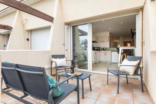 un patio avec des chaises et une table et une cuisine dans l'établissement Maracuja Port Nature, au Cap d'Agde