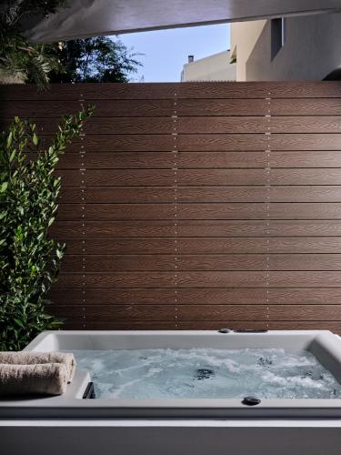 a bath tub in front of a wooden fence at Bond Smart Living Suites in Athens