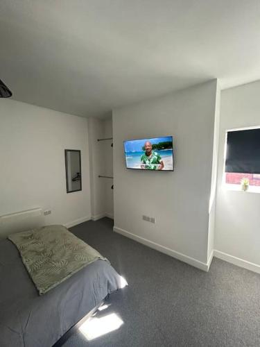 a bedroom with a bed and a tv on the wall at Skegness Town Centre Apartment 1 in Lincolnshire
