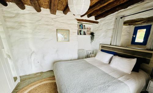 a bedroom with a bed in a white wall at Villa Kotseli - Sea View, Pool, Sunsets in Andros