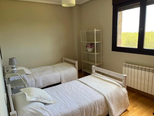 a bedroom with two beds and a window at Apartamento Club de Golf León in León